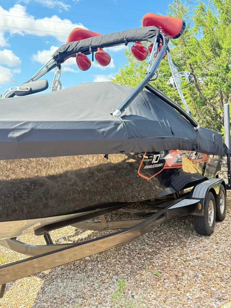 Slide: The Image of 2012 Epic 23V boat with cover on trailer, parked outdoors. - 3