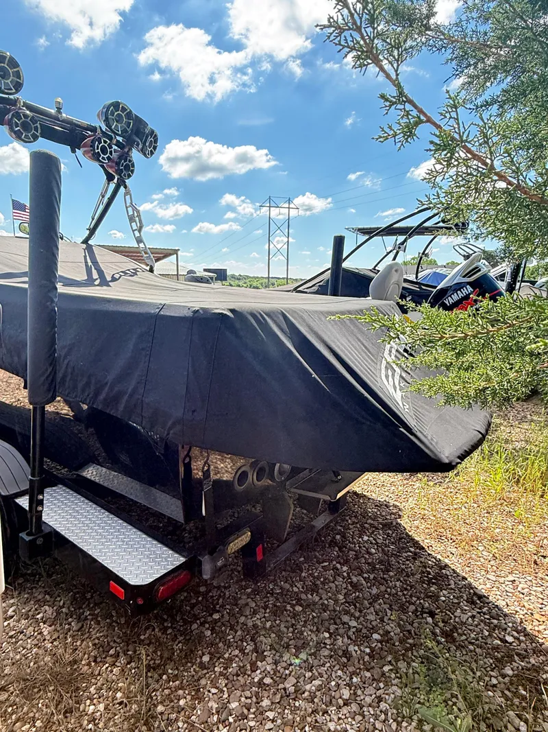 Slide: The Image of Covered 2012 Epic 23V boat on trailer, parked outdoors under a blue sky. - 4