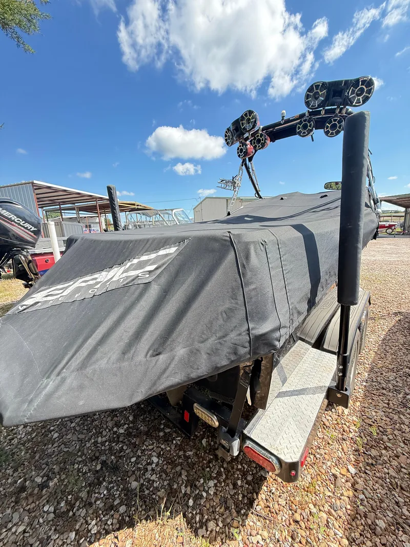 Slide: The Image of 2012 Epic 23V boat covered on trailer under blue sky. - 8