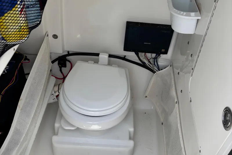 Slide: The Image of 2019 Sea Hunt Gamefish 27 boat interior with marine toilet and storage compartments. - 9