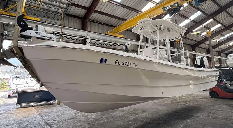 The Image of 2014 Andros Tarpon 26 boat in a warehouse, side view, with registration FL 5721 PP. - 0