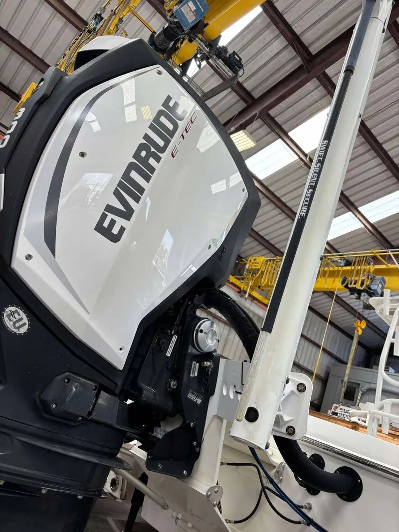 Slide: The Image of 2014 Andros Tarpon 26 with Evinrude engine in a boatyard setting. - 18