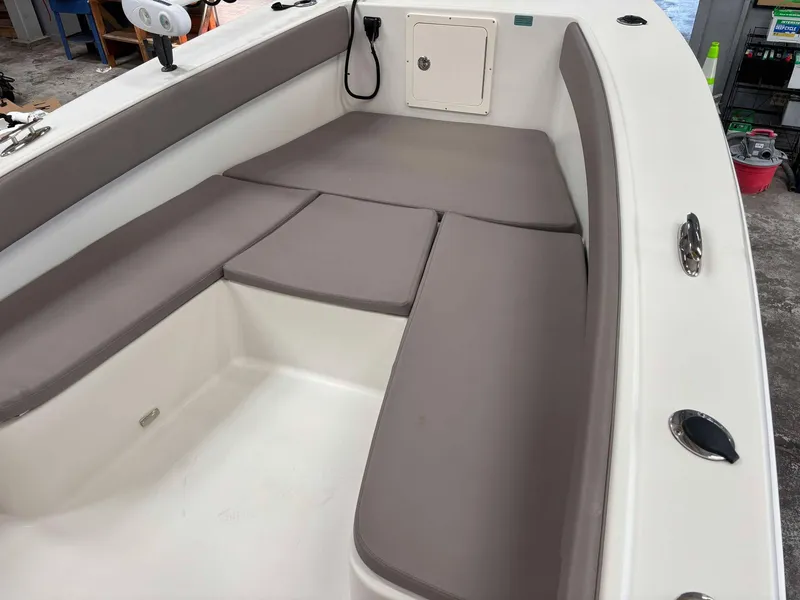 Slide: The Image of 2014 Andros Tarpon 26 boat interior with cushioned seating and storage compartment. - 6