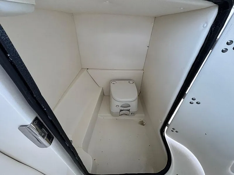 Slide: The Image of 2011 Sea Ray 240 Sundeck boat interior with compact marine toilet. - 11