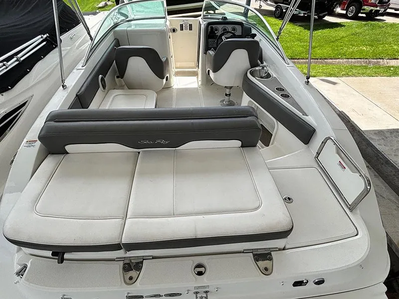 Slide: The Image of 2011 Sea Ray 240 Sundeck boat interior with seating and helm, docked outdoors. - 3