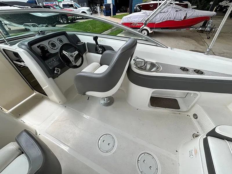 Slide: The Image of 2011 Sea Ray 240 Sundeck boat interior with helm, seating, and cup holders. - 8