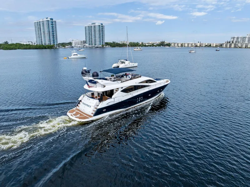 Slide: The Image of Sunseeker 75 Yacht 2006 cruising on a calm waterway with cityscape background. - 12