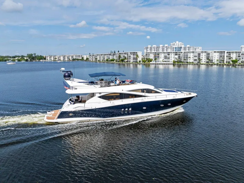 Slide: The Image of Sunseeker 75 Yacht 2006 cruising on a calm lake with modern buildings in the background. - 15