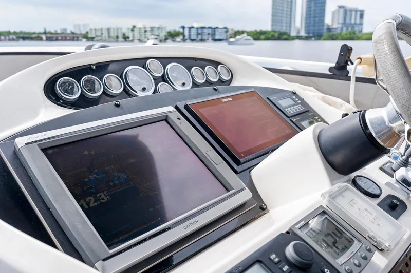 Slide: The Image of Control panel of a 2006 Sunseeker 75 Yacht with navigation screens and gauges. - 49
