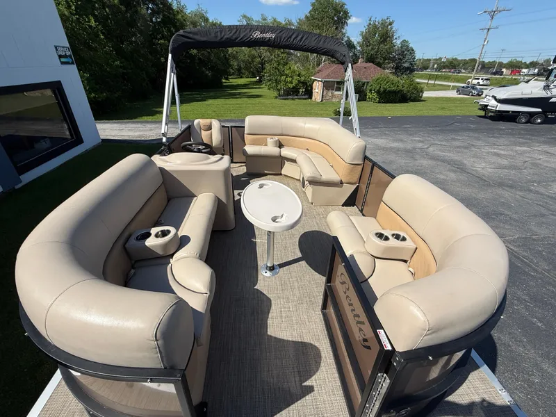Slide: The Image of 2019 Bentley Pontoons 180 CRUISE with beige seating and canopy, parked outdoors. - 8