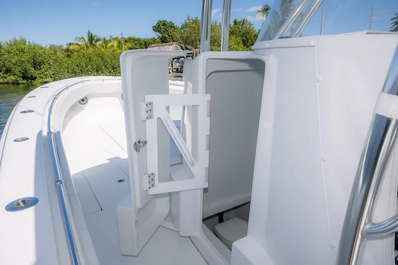 Slide: The Image of 2022 Contender 39 ST boat interior with open storage compartment, sleek white design. - 16