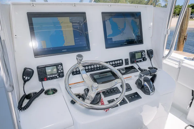 Slide: The Image of 2022 Contender 39 ST boat dashboard with dual Garmin displays and Yamaha controls. - 19