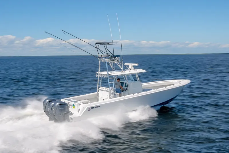 Slide: The Image of 2022 Contender 39 ST boat cruising on open water under clear skies. - 2