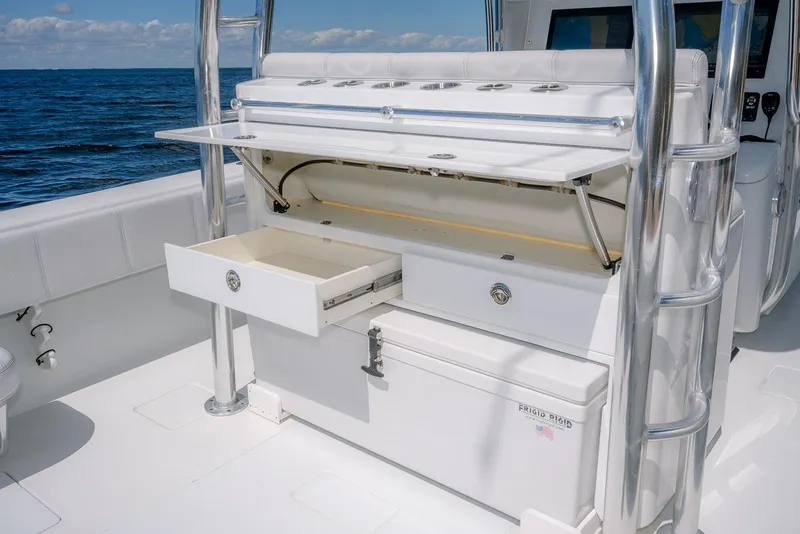 Slide: The Image of 2022 Contender 39 ST boat with open storage compartments and ocean backdrop. - 22