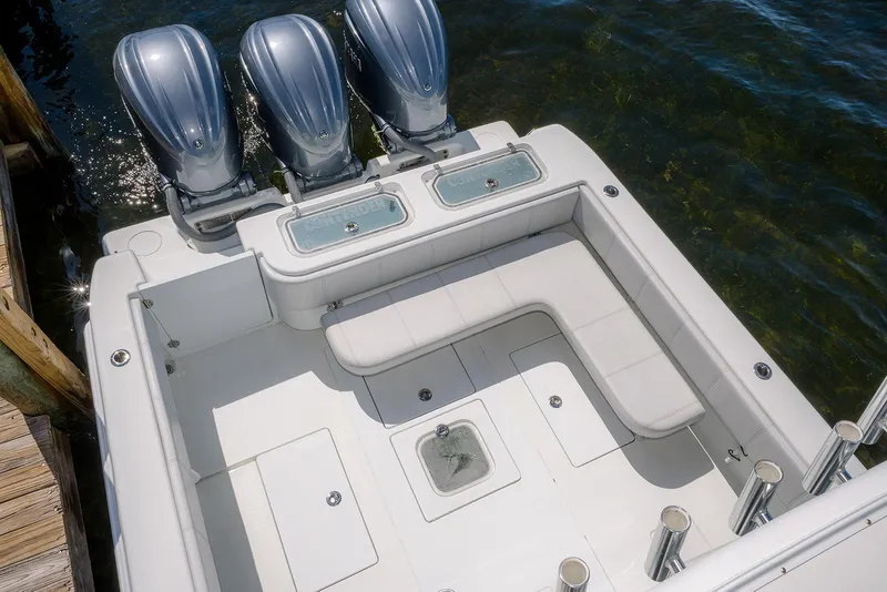 Slide: The Image of 2022 Contender 39 ST boat with triple outboard engines, spacious deck, and seating area. - 23