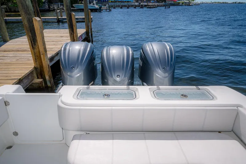 Slide: The Image of 2022 Contender 39 ST boat with triple outboard engines docked by the water. - 26