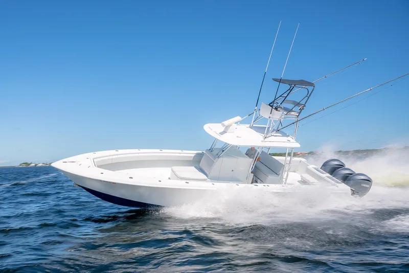 Slide: The Image of 2022 Contender 39 ST boat speeding on open water under clear blue sky. - 4