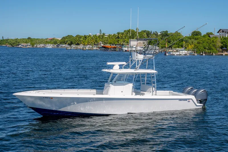 Slide: The Image of 2022 Contender 39 ST boat on calm water, featuring dual outboard motors. - 6