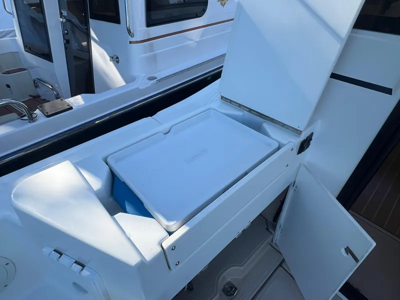 Slide: The Image of 2016 Cutwater C28 boat with open storage compartment and cooler on deck. - 10