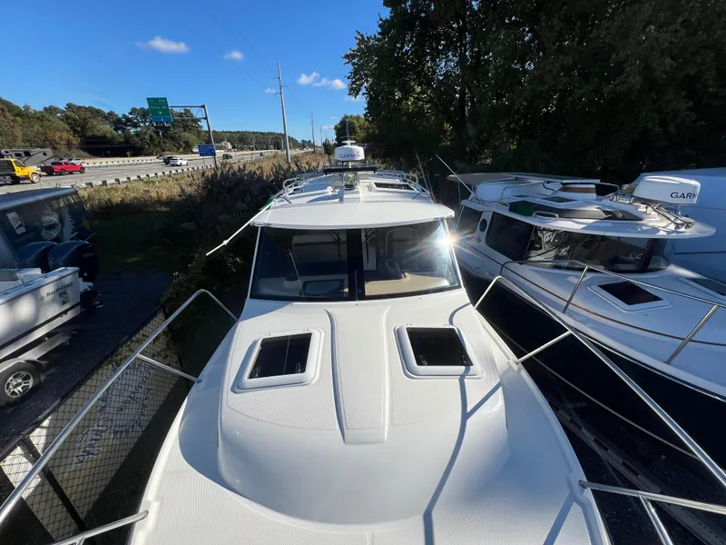 Slide: The Image of 2016 Cutwater C28 boat docked near highway, surrounded by other boats, under clear blue sky. - 12