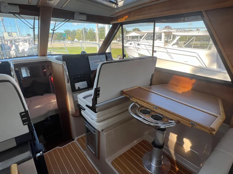 Slide: The Image of Interior of 2016 Cutwater C28 boat with wooden table and seating area. - 21