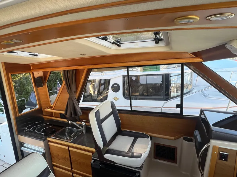Slide: The Image of Interior of a 2016 Cutwater C28 boat featuring a compact kitchen and seating area. - 22
