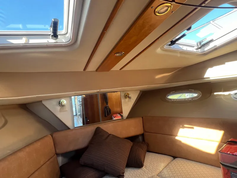 Slide: The Image of Interior of a 2016 Cutwater C28 boat, featuring a cozy seating area with cushions. - 42