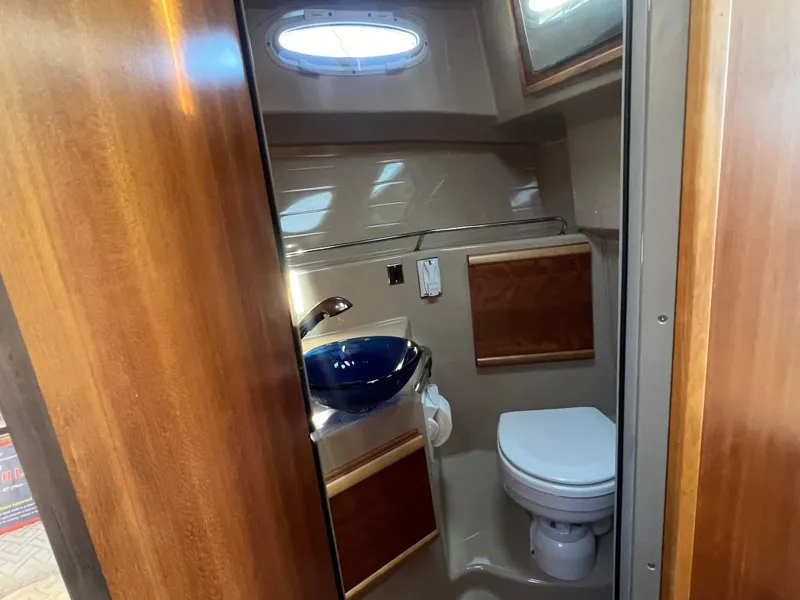 Slide: The Image of 2016 Cutwater C28 boat bathroom with wooden accents, blue sink, and toilet. - 43
