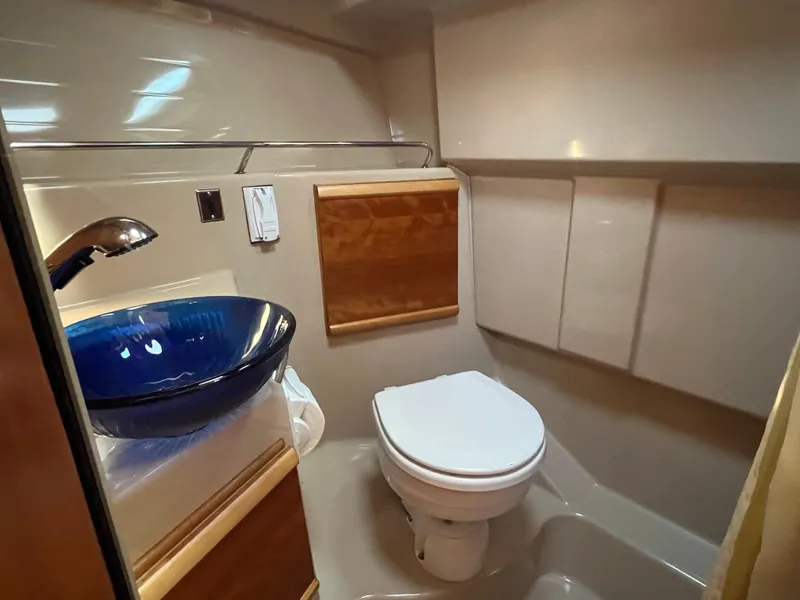 Slide: The Image of 2016 Cutwater C28 boat bathroom with blue glass sink and modern fixtures. - 44