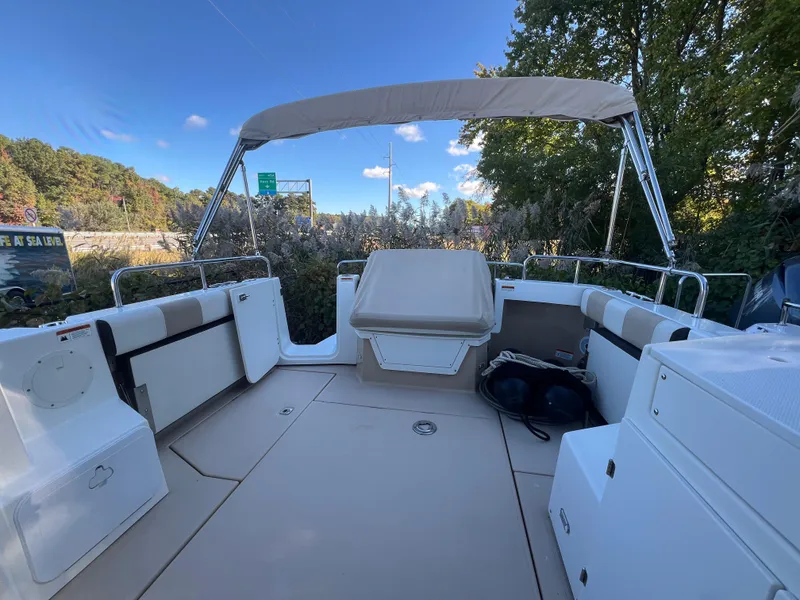 Slide: The Image of 2016 Cutwater C28 boat deck with seating, canopy, and scenic background. - 7