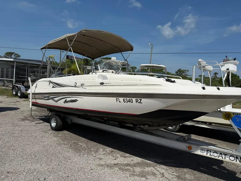 Slide: The Image of 2002 Hurricane FunDeck 211 O/B boat on trailer, parked outdoors under clear sky. - 14