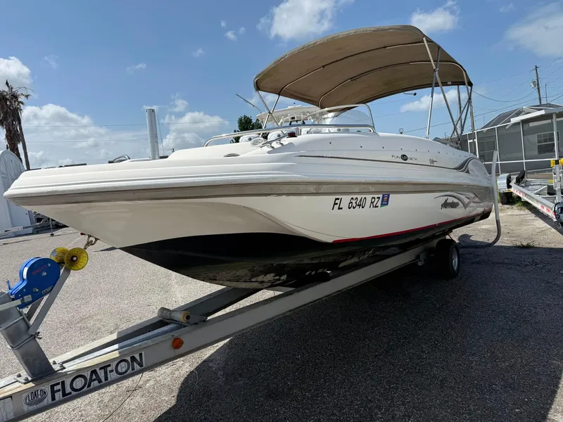 Slide: The Image of 2002 Hurricane FunDeck 211 O/B boat on trailer with canopy, parked outdoors. - 21