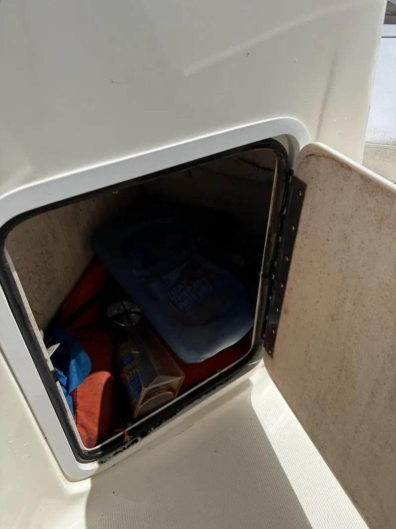 Slide: The Image of Storage compartment on a 2002 Hurricane FunDeck 211 O/B boat with various items inside. - 23