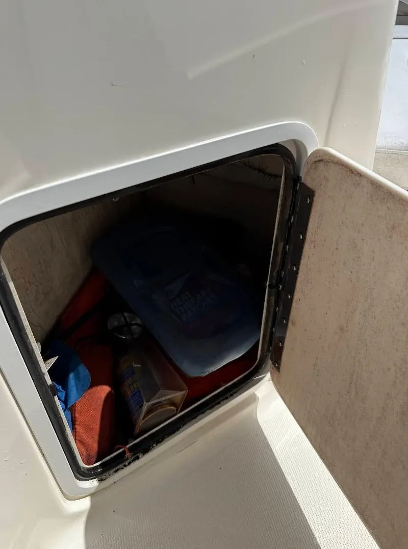 Slide: The Image of Storage compartment on a 2002 Hurricane FunDeck 211 O/B boat, containing various items. - 9