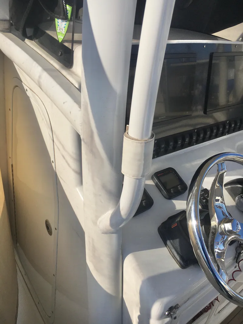Slide: The Image of 2014 Sea Hunt Gamefish 25 boat console with steering wheel and controls. - 10