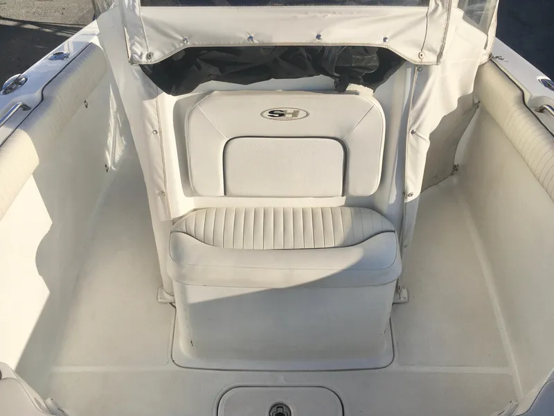 Slide: The Image of 2014 Sea Hunt Gamefish 25 boat interior with white seating and protective cover. - 15