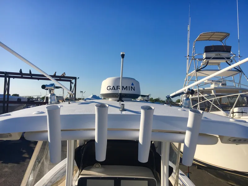 Slide: The Image of 2014 Sea Hunt Gamefish 25 boat with Garmin radar, docked under clear blue sky. - 17