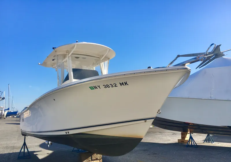 Slide: The Image of 2014 Sea Hunt Gamefish 25 boat on stands under clear blue sky. - 2