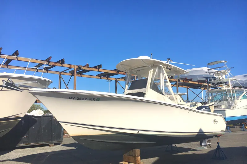 Slide: The Image of 2014 Sea Hunt Gamefish 25 boat on display in a marina under clear blue sky. - 4