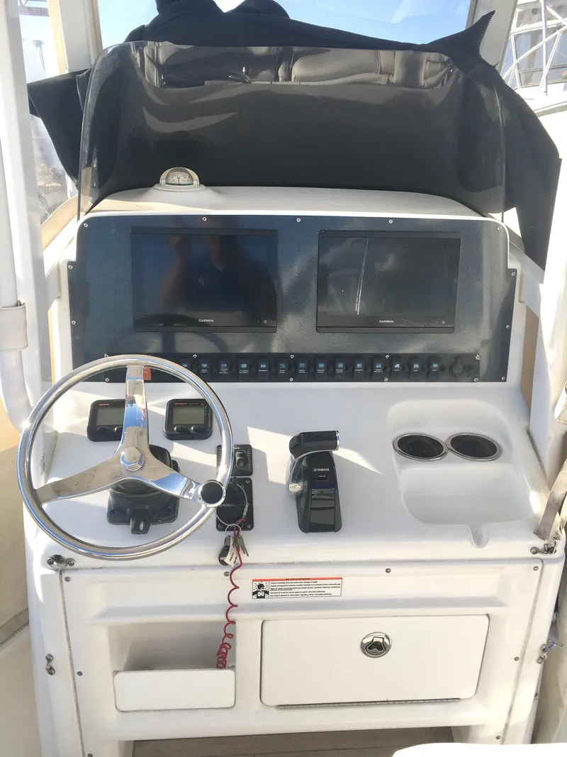 Slide: The Image of 2014 Sea Hunt Gamefish 25 helm with dual displays and steering wheel. - 7