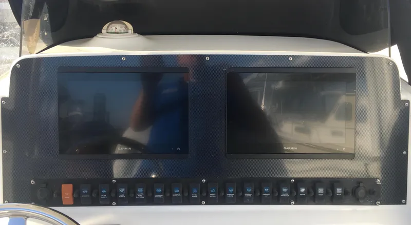 Slide: The Image of 2014 Sea Hunt Gamefish 25 dashboard with dual Garmin displays and control panel. - 8