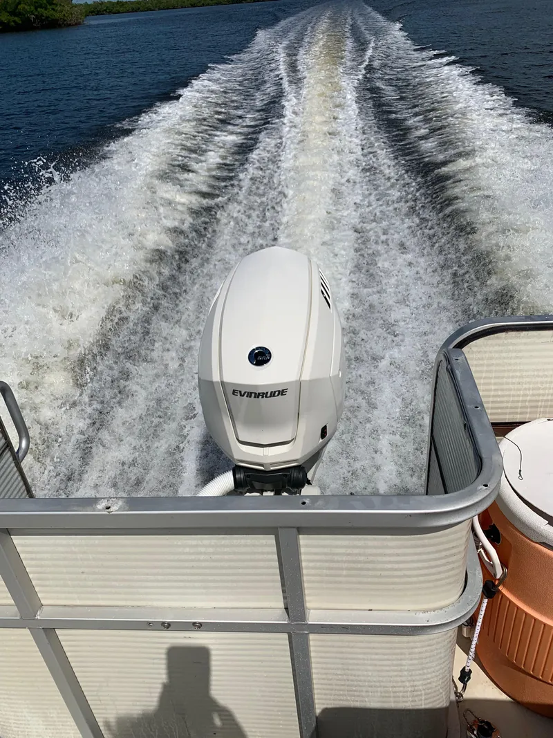 Slide: The Image of 1997 Sylvan Deck Boat cruising on water, leaving a wake behind. - 12