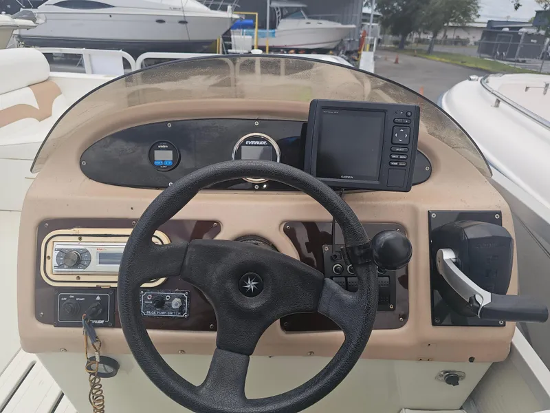 Slide: The Image of 1997 Sylvan Deck Boat dashboard with steering wheel and navigation equipment. - 9