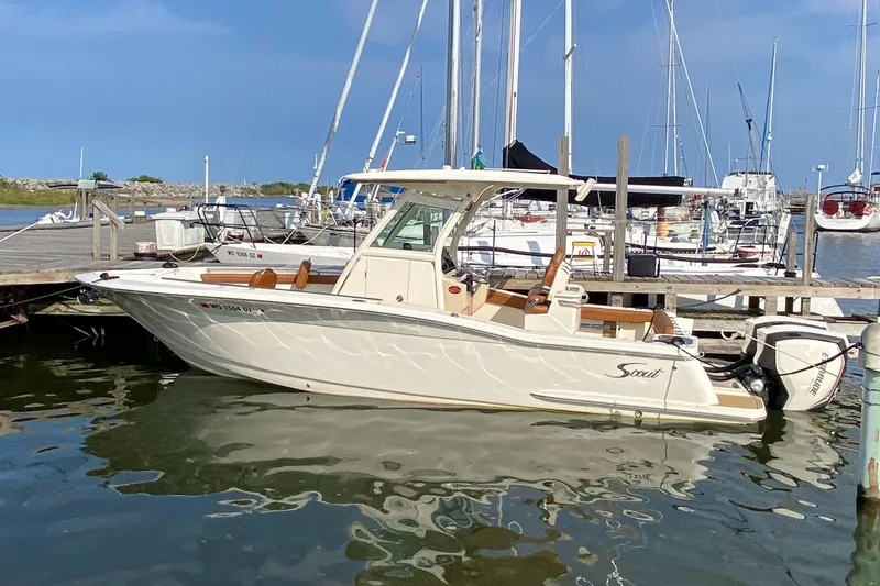 Slide: The Image of 2016 Scout 255 LXF boat docked at marina under clear blue sky. - 0
