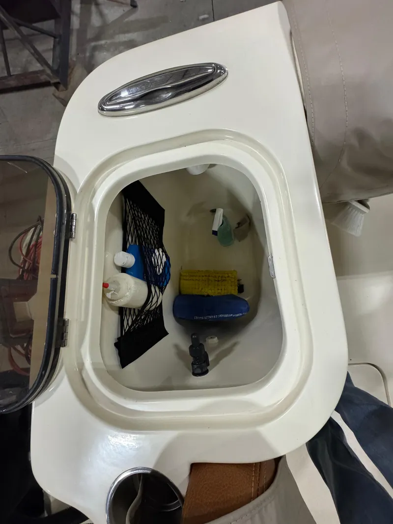 Slide: The Image of Storage compartment on a 2016 Scout 255 LXF boat with cleaning supplies. - 25