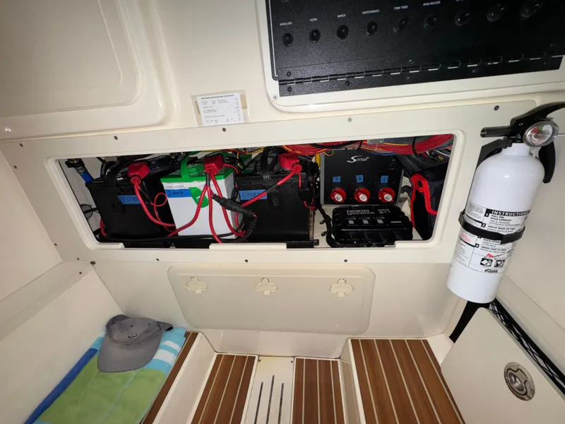 Slide: The Image of Electrical compartment of 2016 Scout 255 LXF boat with batteries and fire extinguisher. - 26