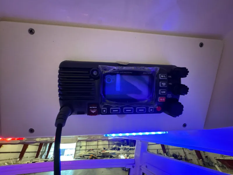 Slide: The Image of VHF radio installed on a 2016 Scout 255 LXF boat, illuminated by blue and red lights. - 30