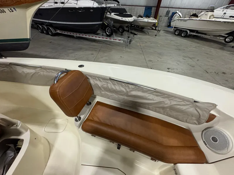 Slide: The Image of 2016 Scout 255 LXF boat interior with brown leather seating in a showroom. - 38