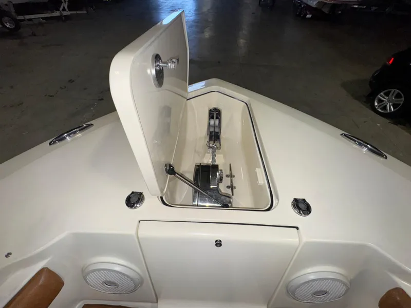 Slide: The Image of 2016 Scout 255 LXF boat anchor compartment with open hatch in a garage setting. - 41