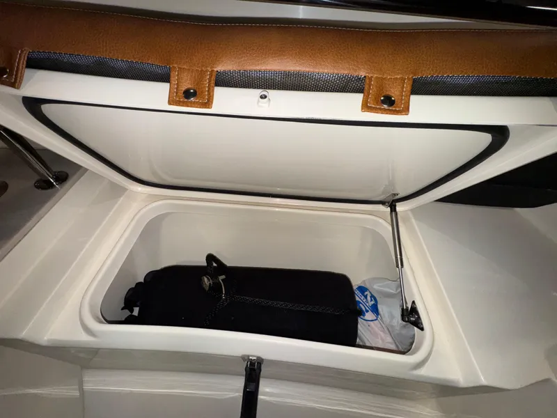 Slide: The Image of Storage compartment in a 2016 Scout 255 LXF boat, featuring a brown trim. - 45